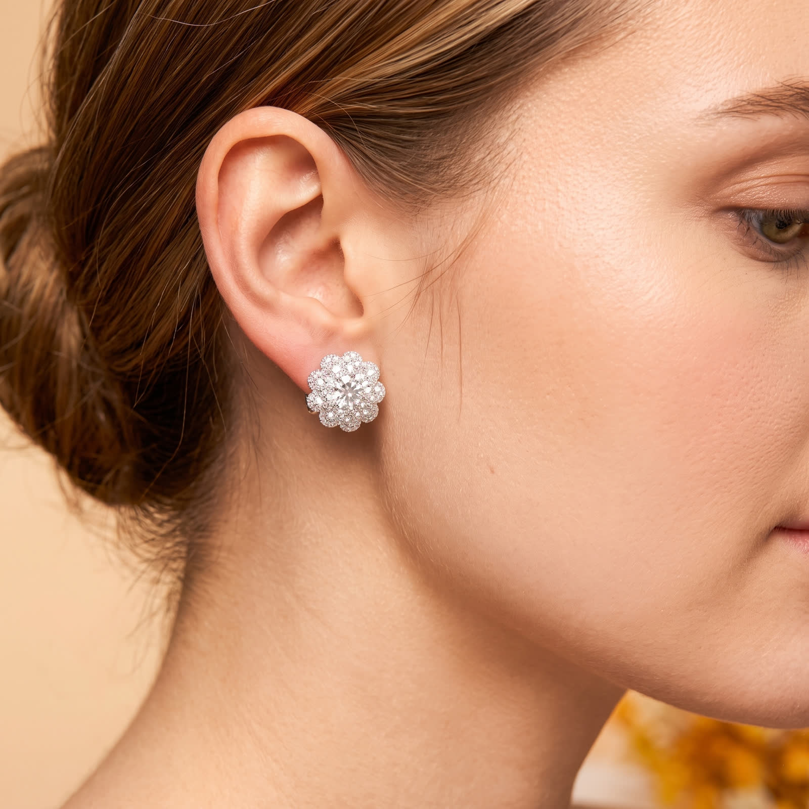 Round CZ floral halo earrings worn on the ear