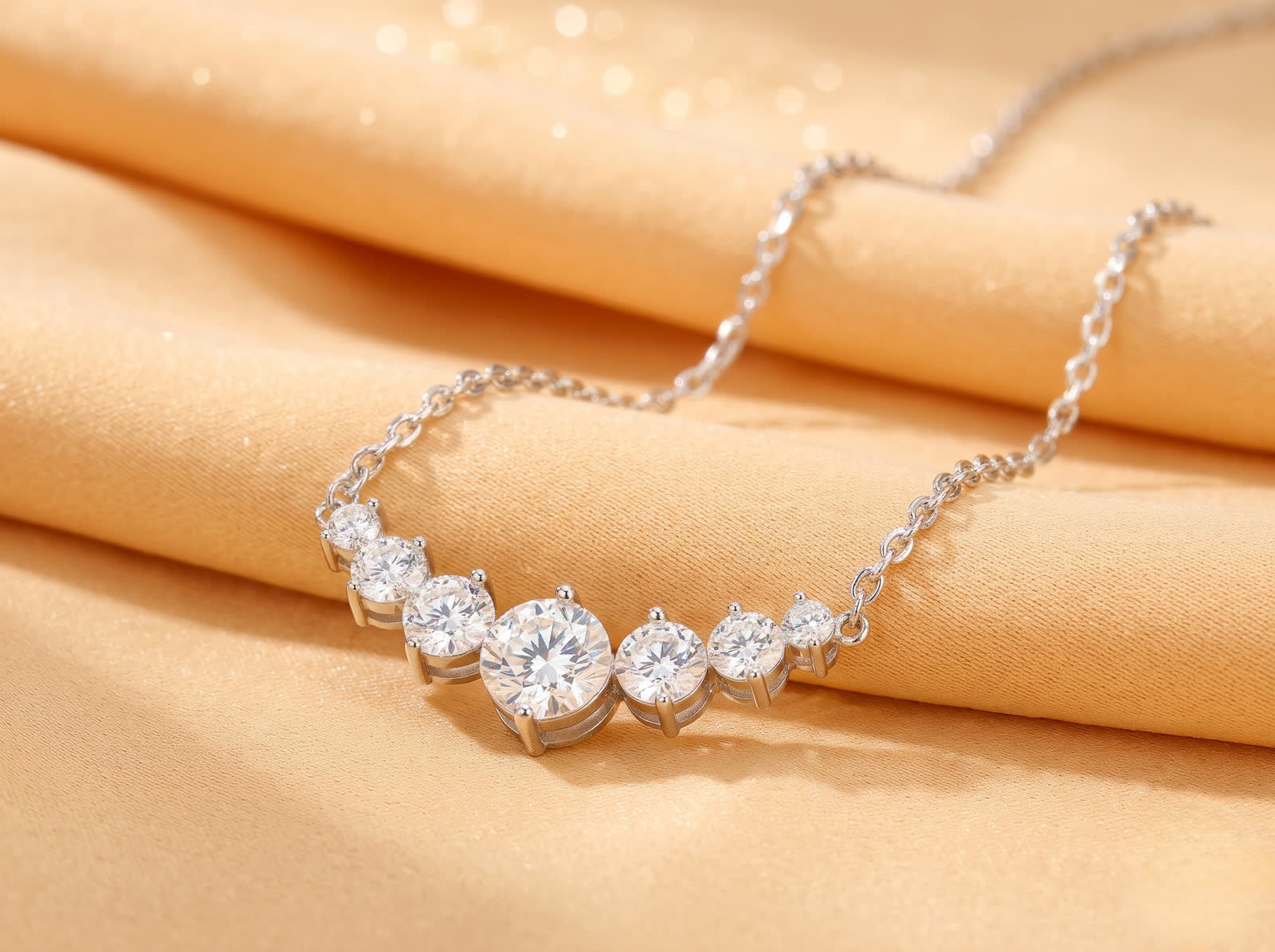Graduated round-stone necklace shown at an angle with open-backed settings
